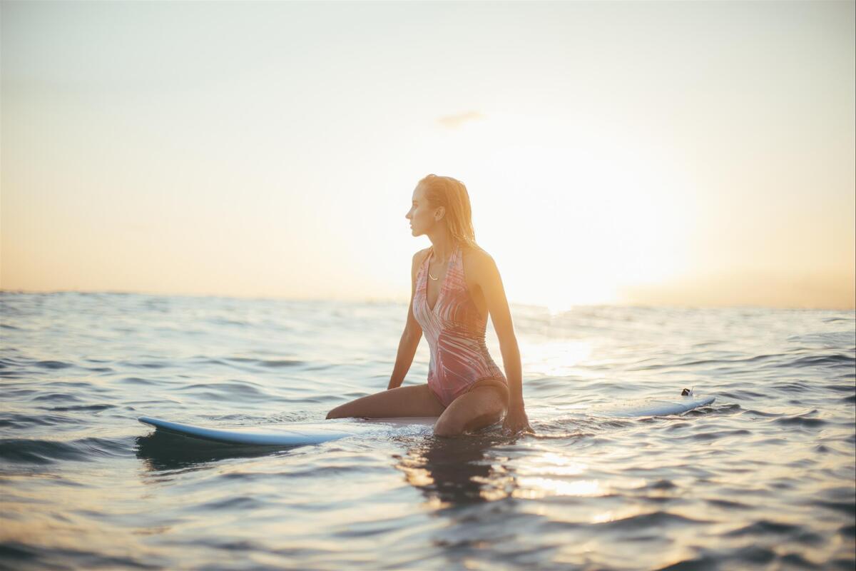 girl sitting on surfboard